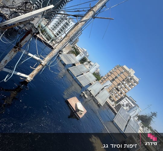 גג עם חומרי איטום, קולטי שמש וחוטי חשמל.